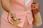 Woman in Pink is Giving a Gold Credit Card